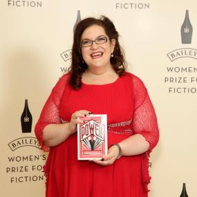 Photograph of Naomi Alderman, standing and holding her novel, The Power, at the Baileys Women's Prize for Fiction event, Royal Albert Hall,
            London, 7 June 2017.